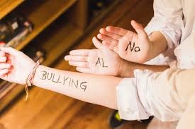 Manos y brazo escrito con "no más bullying"