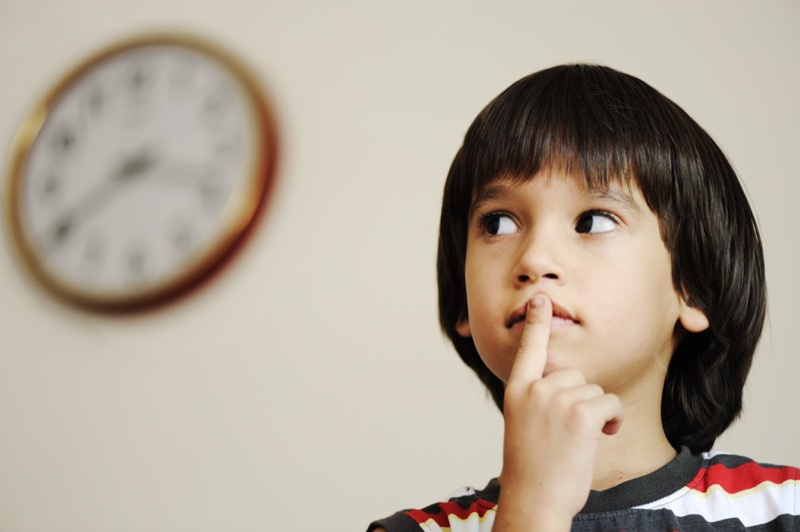 Conciencia fonológica La imagen muestra a un niño con el dedo sobre la boca y los ojos mirando hacia el lado, pensando en algo