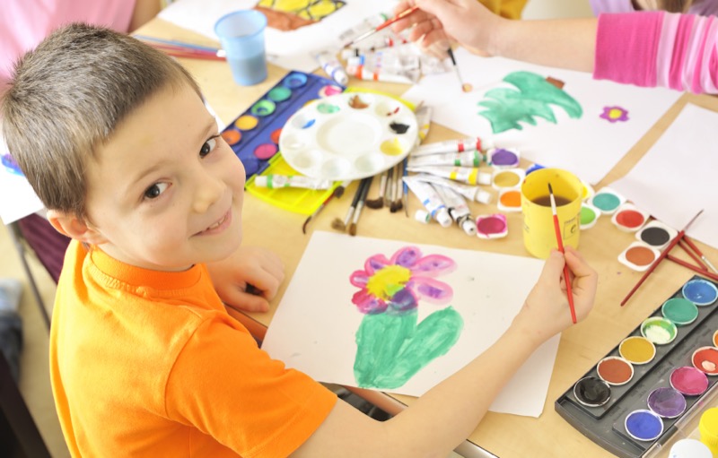 Composiciones artísticas La imagen muestra a un niño realizando un dibujo con tempera