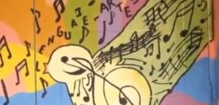 Imagen de puerta pintada con una pájaro que tiene dibujado notas musicales.