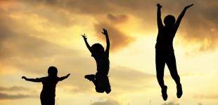 La imagen muestra a tres personas que saltan, manifestando optimismo