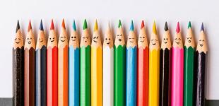 Fotografía de lápices de distintos colores con diversas expresiones de emociones.