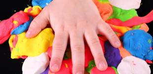 Imagen que muestra una mano de niño o niña encima de varias  plasticinas