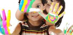 La imagen muestra a dos niños con sus manos pintadas 