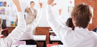 La imagen muestra una sala de clases con alumnos participando