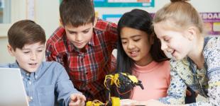 Niños y niñas creando un aparato tecnológico