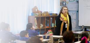Fotografía de docente enseñando a estudiantes en sala de clases.