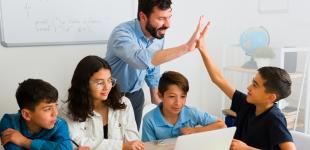 Profesor chocando la mano de uno de los estudiantes de su grupo de estudio