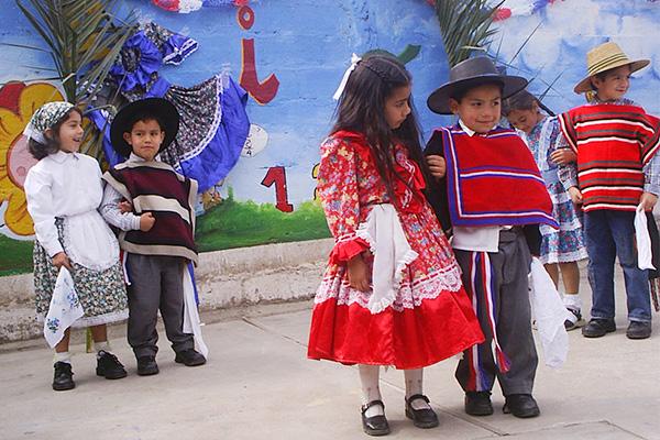 Pareja de estudiantes bailando cueca en un establecimiento educacional.