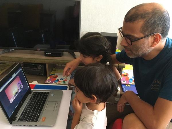 Padre junto a sus hijos pequeños viendo una serie en plataforma online