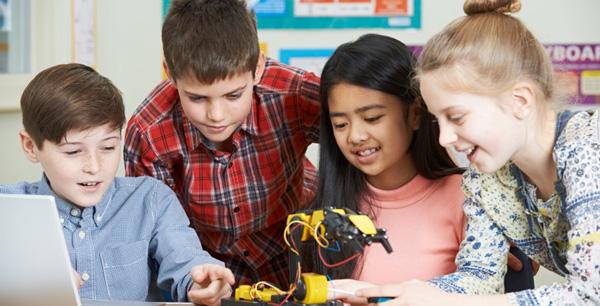 Niños y niñas creando un aparato tecnológico