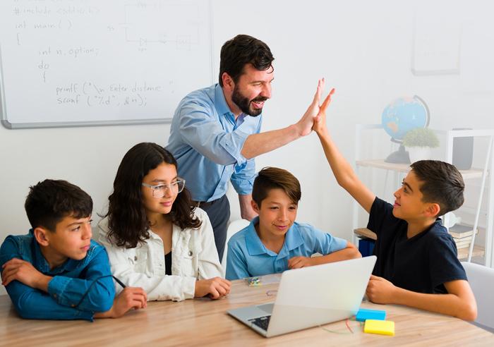 Profesor chocando la mano de uno de los estudiantes de su grupo de estudio