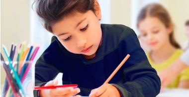 niña escribiendo en la sala de clases