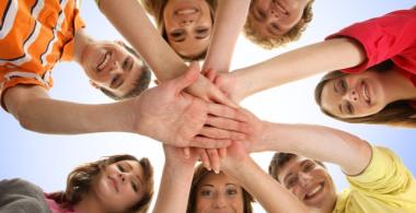 grupo de jóvenes tomándose de la mano en círculo