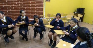 Niñas escolares sentadas en círculo con actitud de conversación
