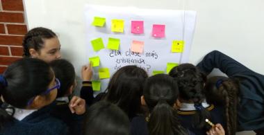 Niños reunidos en la pizarra