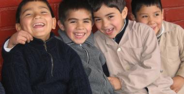 cuatro niños se abrazan y sonríen
