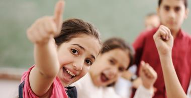 niños sonriendo y levantando el dedo meñique