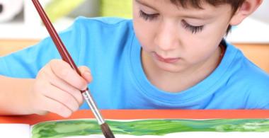 La imagen muestra a un niño pequeño realizando una actividad artística