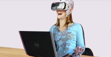 Mujer frente a computador usando lentes de realidad virtual