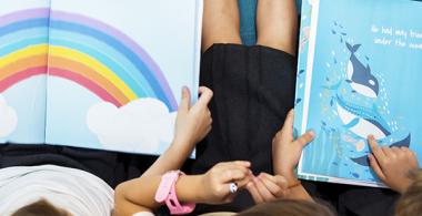La imagen muestra a niños observando figuras en libros