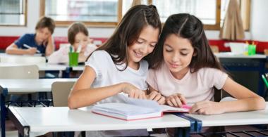 dos estudiantes leyendo juntas un texto